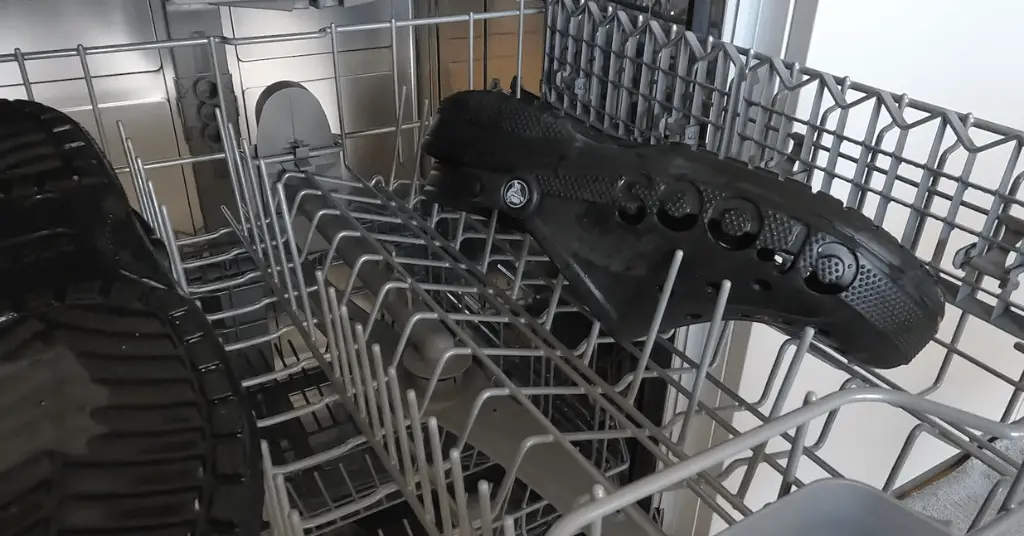 Black crocs placed on the upper dishwasher shelf