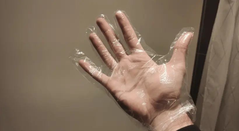 one time use plastic glove on a hand