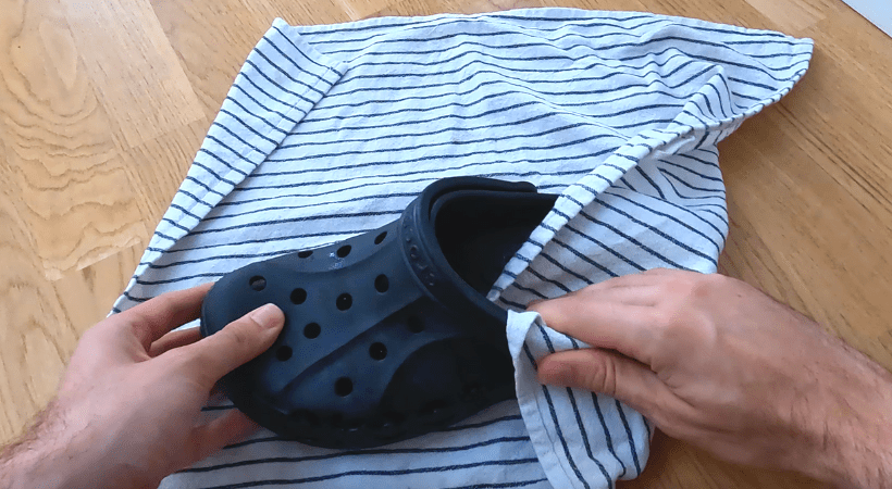 A single Crocs clog dried by an absorbent cloth