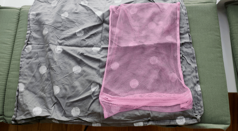 A mesh bag for shoes and a grey pillow case