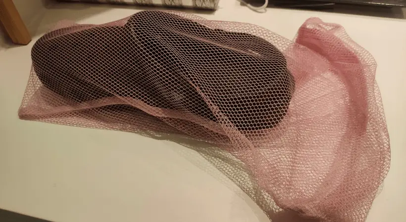 A single Crocs clog inside the mesh bag for shoes