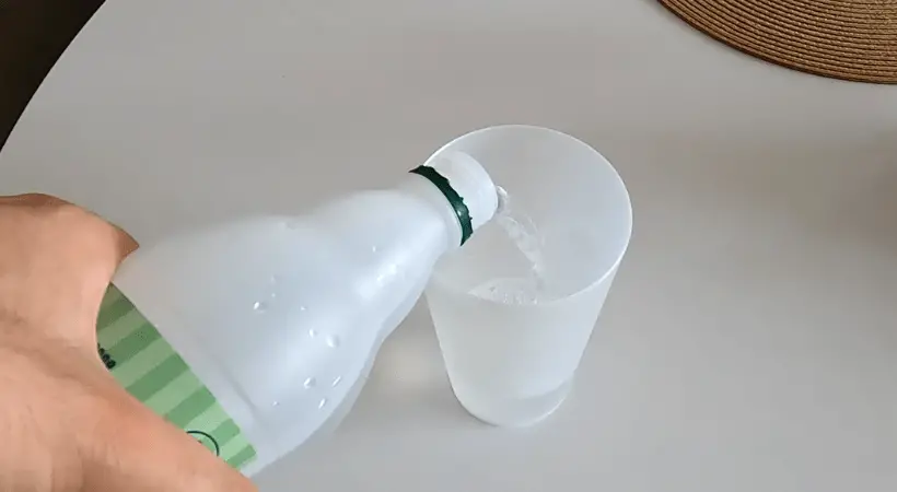 White vinegar is being poured into a dishwasher friendly cup