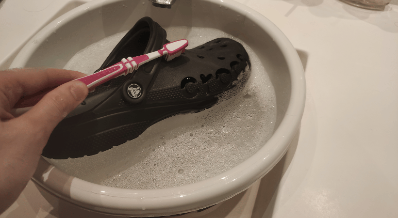 Crocs in soapy water cleaned with a toothbrush