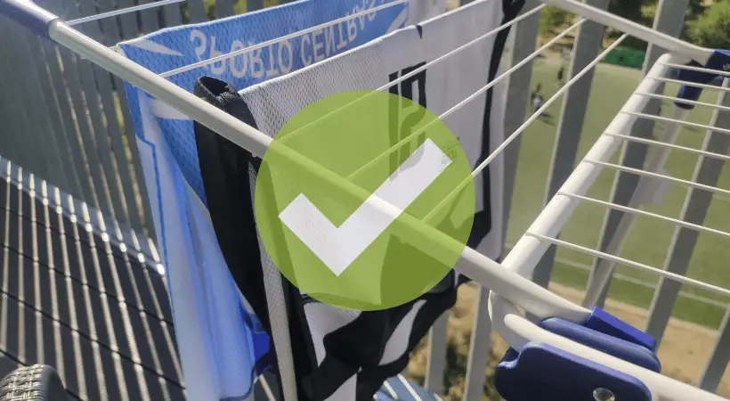 A drying rack outside in a shaded area with sports jerseys air drying and a yes sign as an overlay.